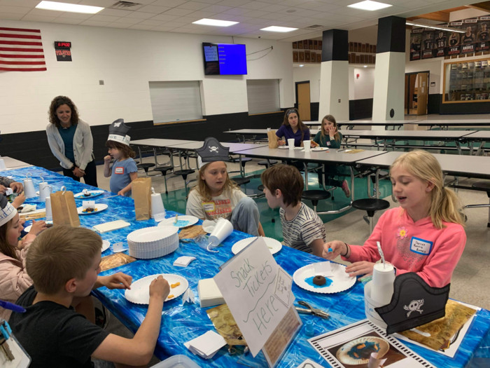 Students work on craft project at cafeteria table